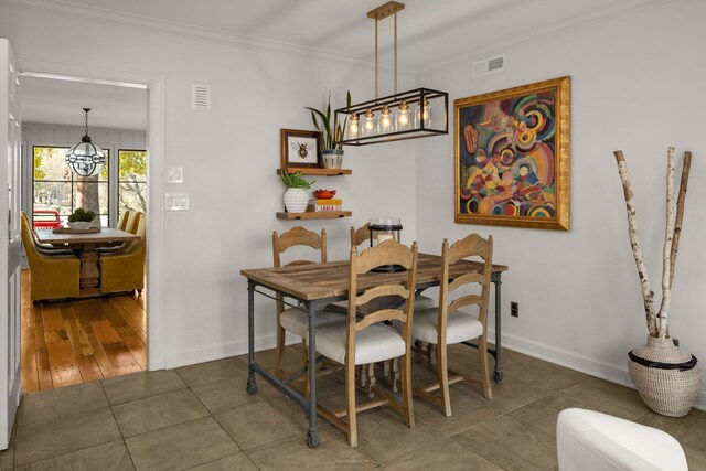 dining space featuring an inviting chandelier, crown molding, and dark wood-type flooring