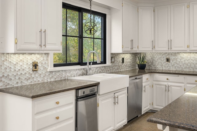 kitchen featuring sink, backsplash, white cabinetry, stainless steel dishwasher, and dark stone countertops