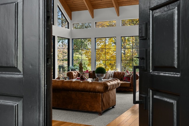 living room with lofted ceiling with beams, wooden ceiling, and light hardwood / wood-style flooring