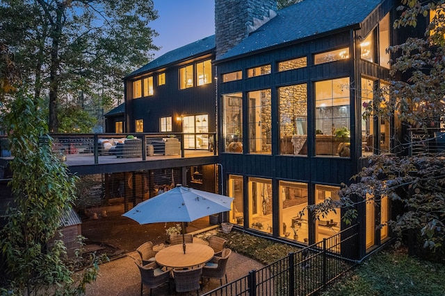 back house at dusk featuring a patio