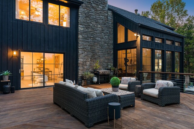 deck at dusk with an outdoor hangout area and a grill