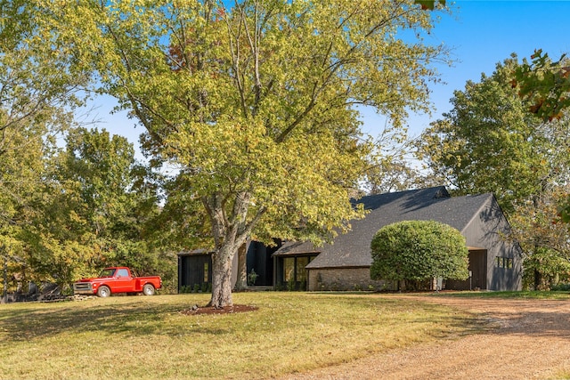 view of property hidden behind natural elements with a front yard