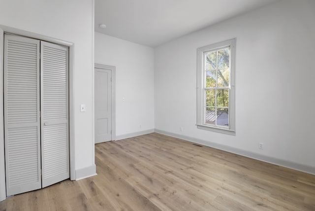 unfurnished bedroom with a closet and light wood-type flooring