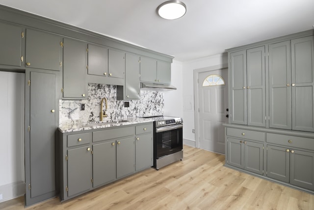 kitchen with gray cabinetry, tasteful backsplash, sink, stainless steel electric range, and light hardwood / wood-style flooring