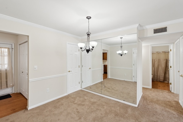 unfurnished room featuring light carpet, an inviting chandelier, and ornamental molding