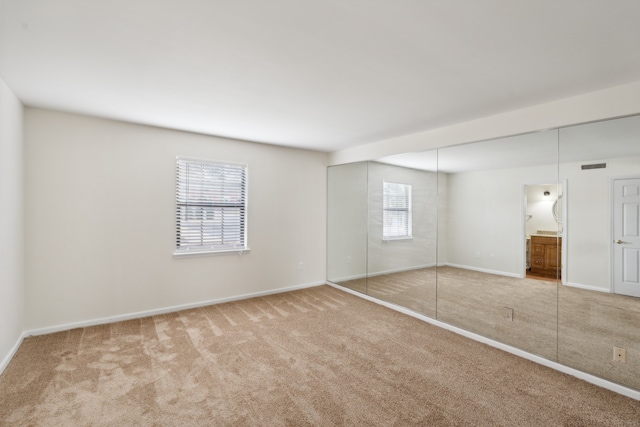 unfurnished bedroom with connected bathroom and carpet