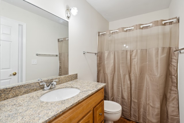 bathroom featuring toilet, vanity, and a shower with shower curtain