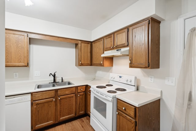 kitchen with white appliances, light hardwood / wood-style floors, and sink