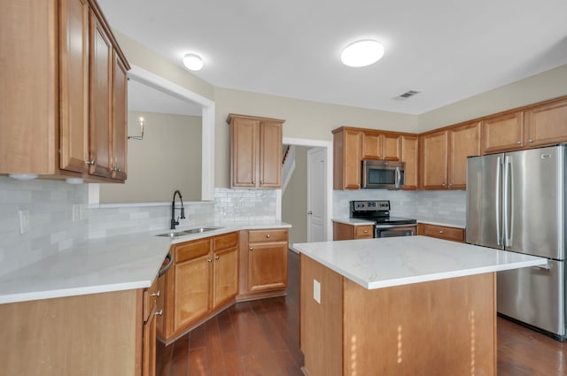 kitchen featuring appliances with stainless steel finishes, dark hardwood / wood-style flooring, tasteful backsplash, sink, and a kitchen island