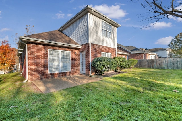 rear view of property featuring a lawn and a patio