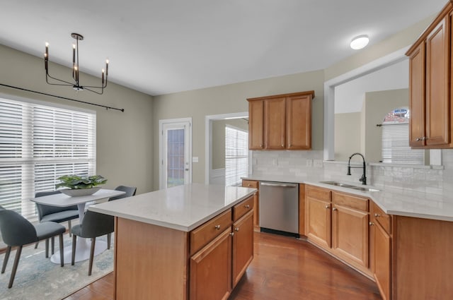 kitchen featuring dark wood-type flooring, sink, stainless steel dishwasher, tasteful backsplash, and a kitchen island