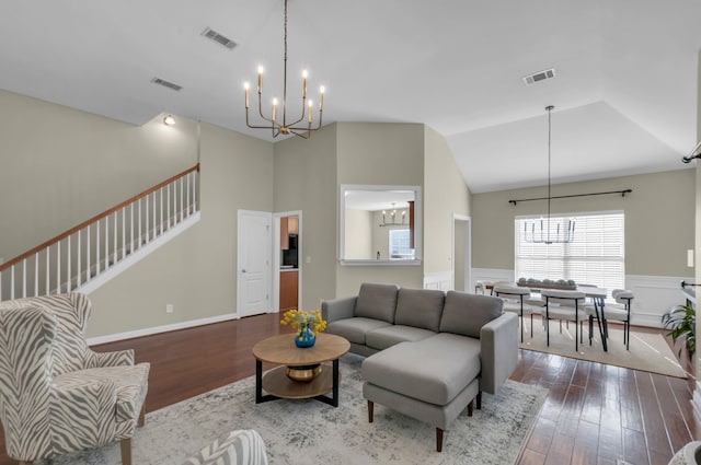 living room featuring a chandelier, hardwood / wood-style floors, and vaulted ceiling