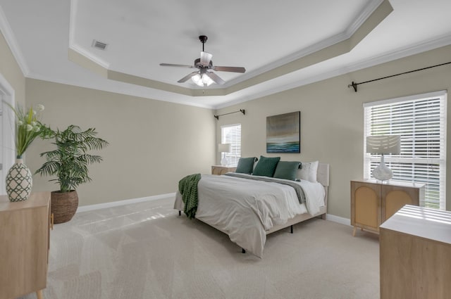 carpeted bedroom featuring multiple windows, a raised ceiling, ceiling fan, and ornamental molding