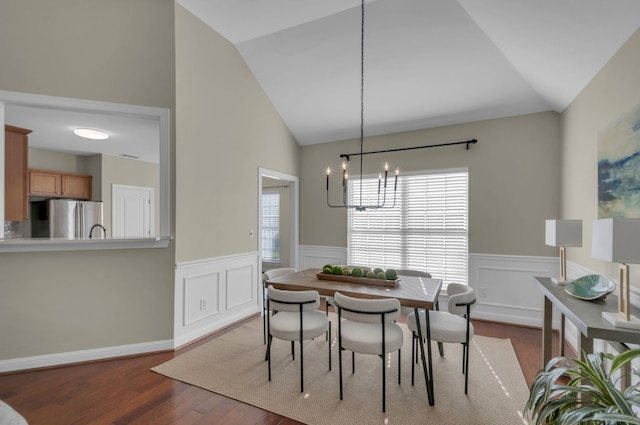 dining space featuring a chandelier, wood-type flooring, and lofted ceiling