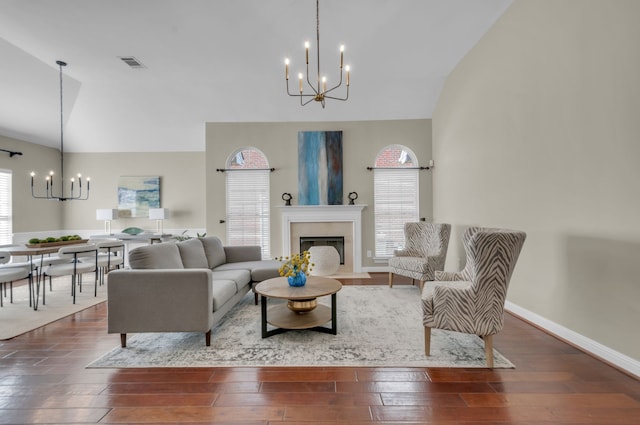 living room featuring high vaulted ceiling, a chandelier, and dark hardwood / wood-style floors