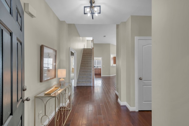 foyer entrance with dark hardwood / wood-style flooring and a chandelier