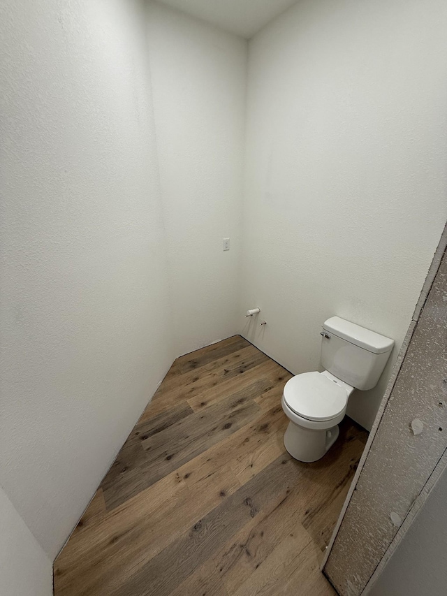 bathroom featuring wood-type flooring and toilet