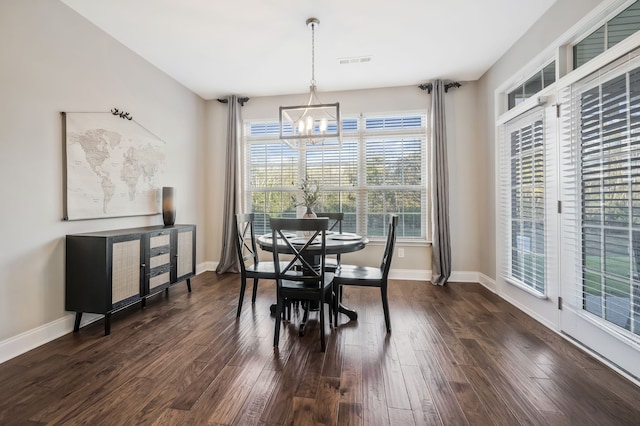 dining room with dark wood-type flooring and an inviting chandelier