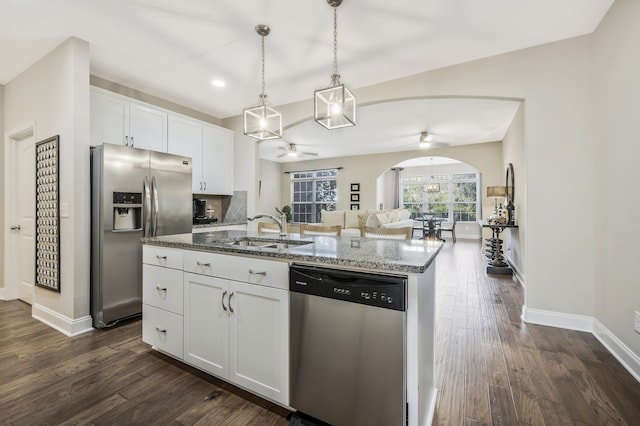 kitchen with a kitchen island with sink, dark wood-type flooring, stainless steel appliances, sink, and white cabinets