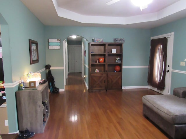 sitting room featuring dark wood-type flooring and a raised ceiling