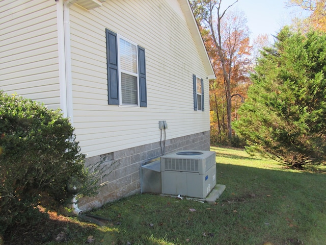 view of home's exterior with central AC and a lawn