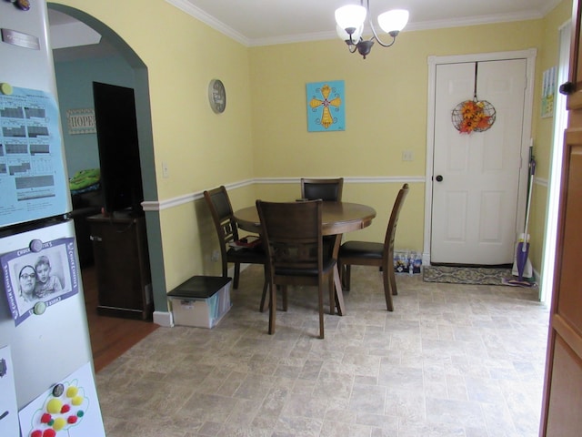 dining room with crown molding and a chandelier