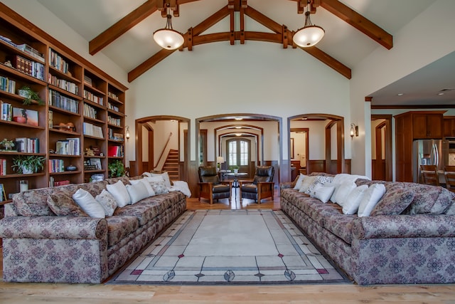 living room with beam ceiling, high vaulted ceiling, and light hardwood / wood-style flooring