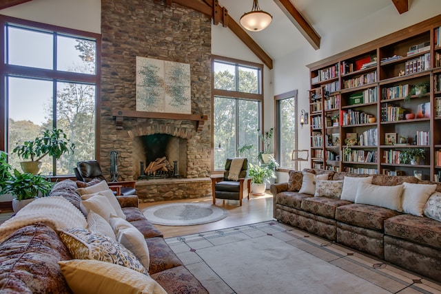 living room with beamed ceiling, a fireplace, and high vaulted ceiling