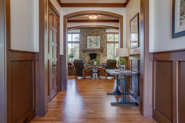 foyer entrance featuring a fireplace, light hardwood / wood-style floors, and ornamental molding