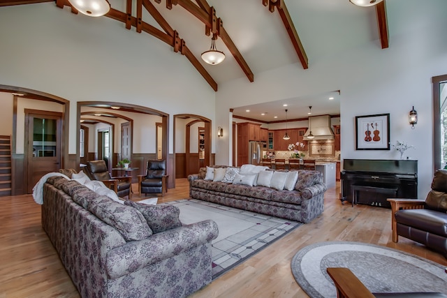 living room featuring beam ceiling, light hardwood / wood-style flooring, and high vaulted ceiling