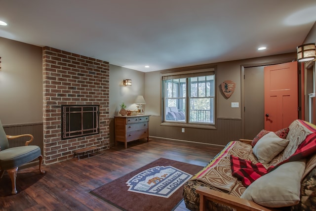 living room with dark wood-type flooring and a brick fireplace