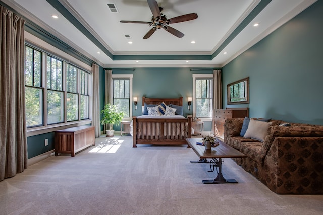 carpeted bedroom featuring ceiling fan, crown molding, and a tray ceiling