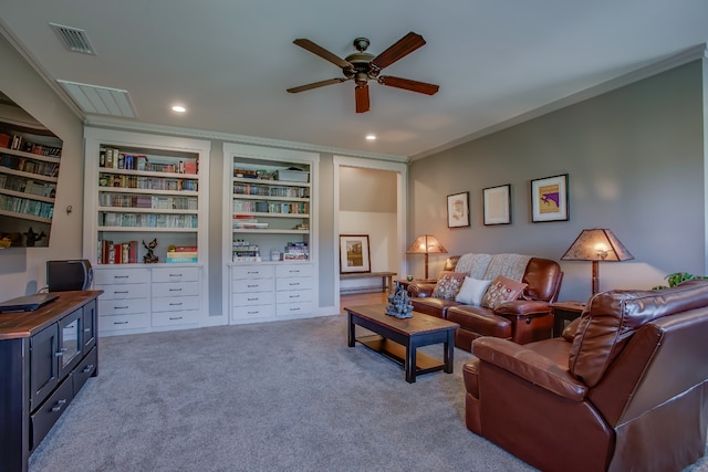 carpeted living room with built in shelves, ceiling fan, and ornamental molding