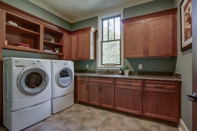 laundry room with ornamental molding, sink, cabinets, and independent washer and dryer