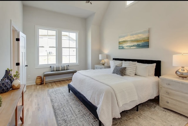 bedroom with light hardwood / wood-style flooring and lofted ceiling