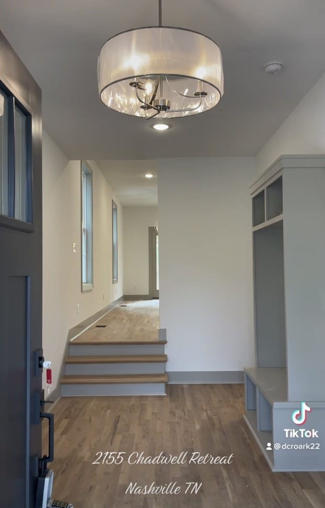 stairway featuring hardwood / wood-style flooring and a chandelier