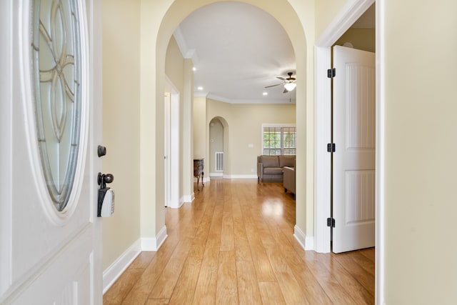 corridor featuring light hardwood / wood-style floors and crown molding