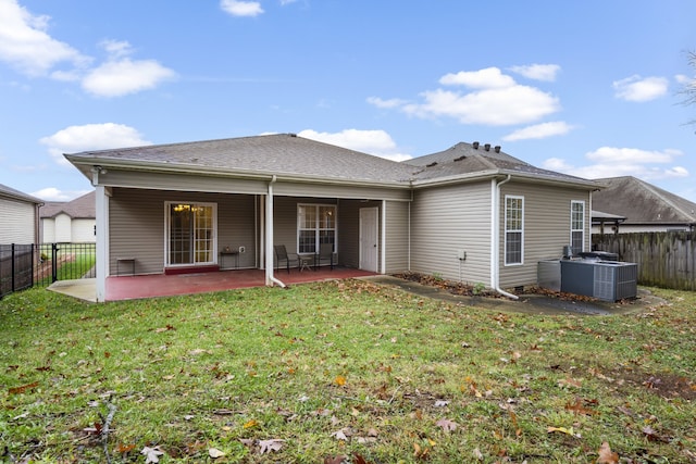 back of house featuring central air condition unit, a lawn, and a patio