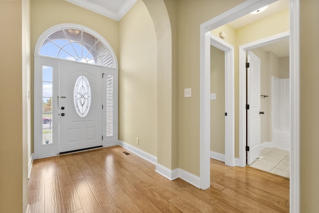 entryway featuring light hardwood / wood-style floors and ornamental molding