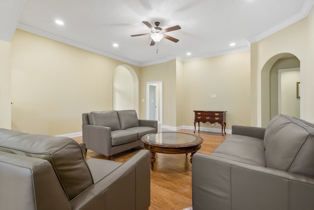 living room featuring light hardwood / wood-style floors, ceiling fan, and crown molding