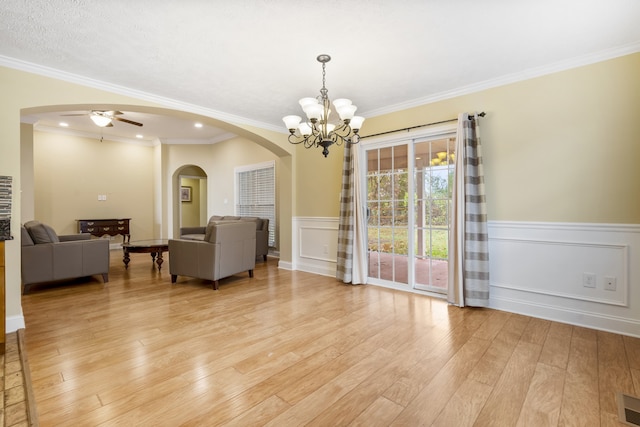 dining area with light hardwood / wood-style floors, ceiling fan with notable chandelier, and crown molding