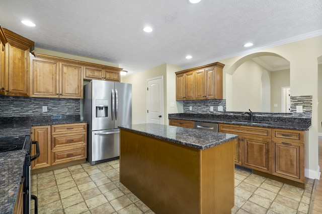 kitchen featuring stainless steel appliances, sink, ornamental molding, tasteful backsplash, and a center island