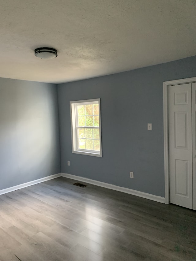 spare room with hardwood / wood-style floors and a textured ceiling