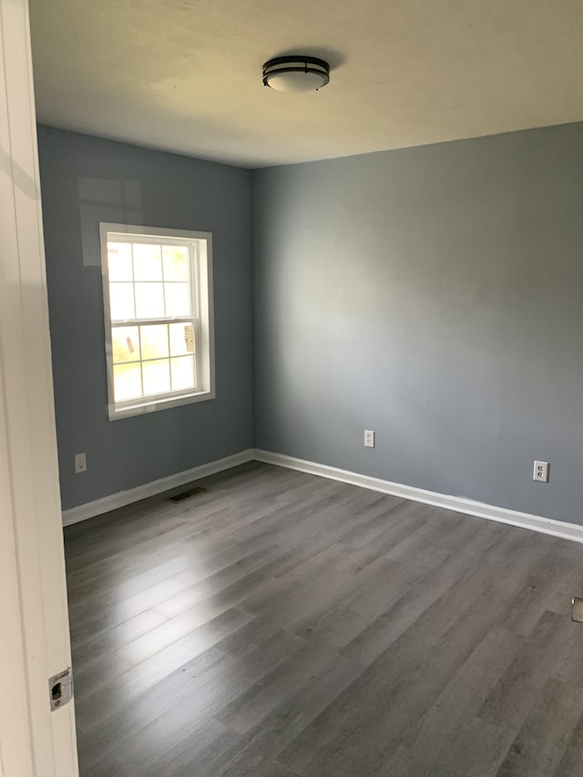 spare room featuring dark wood-type flooring