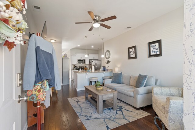 living room featuring dark wood-type flooring and ceiling fan