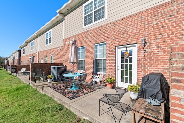 rear view of house featuring a patio, a yard, and central air condition unit