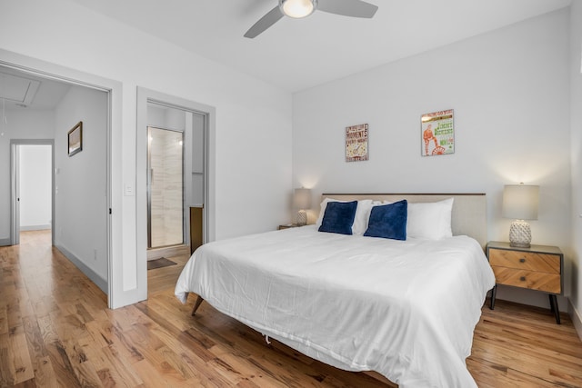 bedroom with ensuite bathroom, light wood-type flooring, and ceiling fan