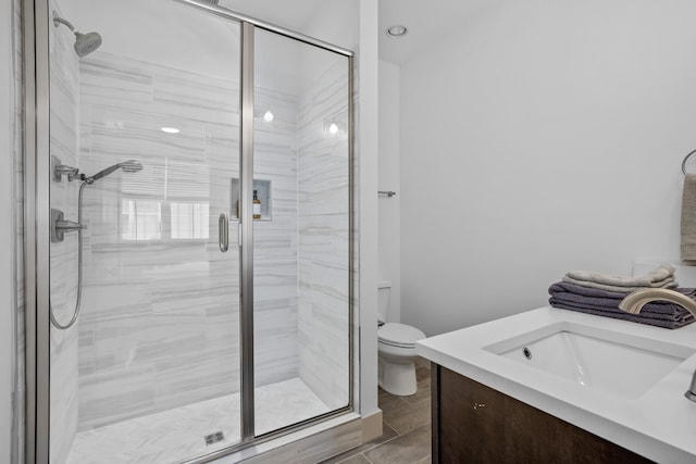 bathroom with vanity, toilet, wood-type flooring, and a shower with door