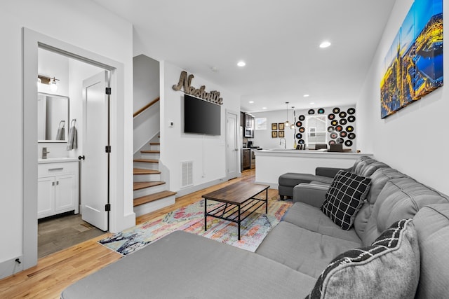 living room with sink and light wood-type flooring