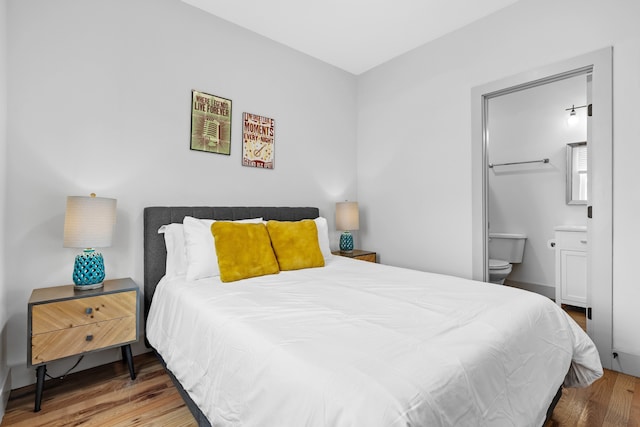 bedroom featuring ensuite bathroom and wood-type flooring